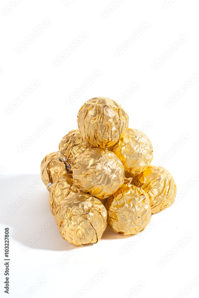 Balls of sweets in golden sweetie paper isolated on white background