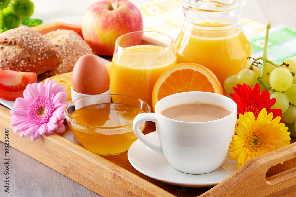 Breakfast on tray served with coffee, juice, egg, and rolls Breakfast on tray served with coffee, juice, egg, and rolls