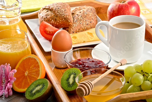 Breakfast on tray served with coffee, juice, egg, and rolls