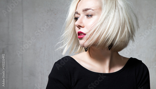 Fotografia Close-up portrait of a beautiful blonde with red lips on a black background