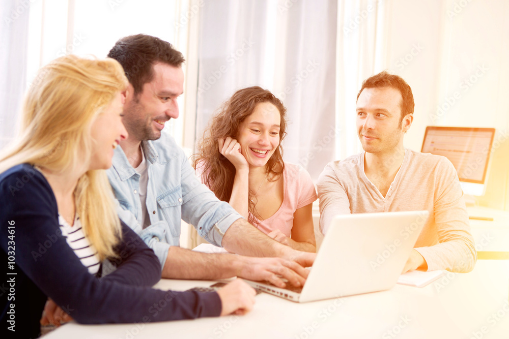 Group of 4 young attractive people working on a laptop Group of 4 young attractive people working on a laptop