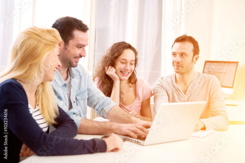 Group of 4 young attractive people working on a laptop © Production Perig