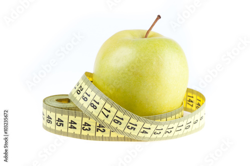 fresh green apple and tape measure isolated on white background