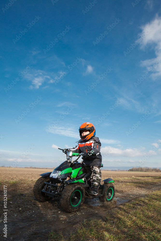 Boy rides on electric ATV quad.