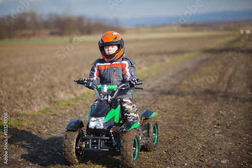 Boy rides on electric ATV quad.