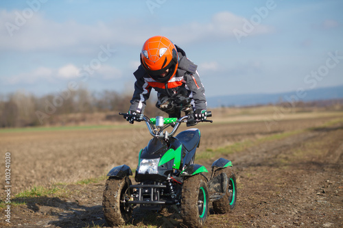 Fototapeta Naklejka Na Ścianę i Meble -  Boy rides on electric ATV quad.