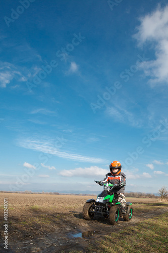 Boy rides on electric ATV quad.