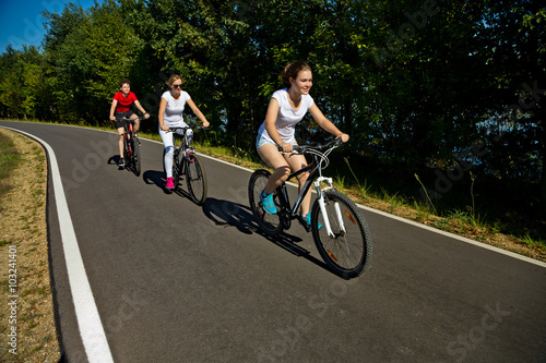 Healthy lifestyle - people riding bicycles in city park 