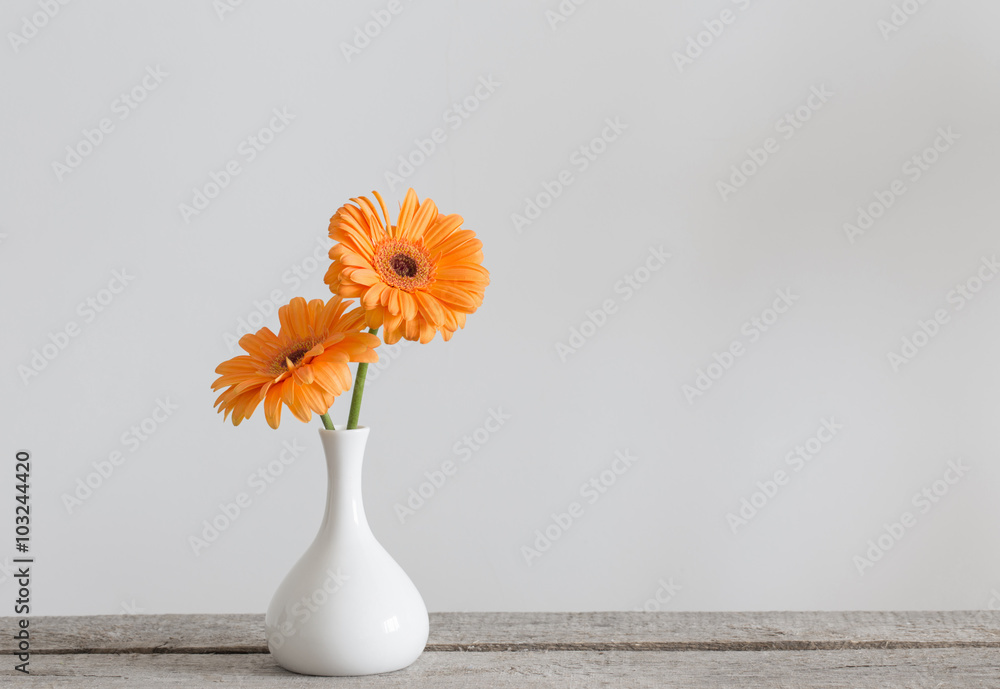Fototapeta premium Gerbera in vase on old wooden table