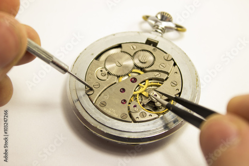 hands repair an old watch