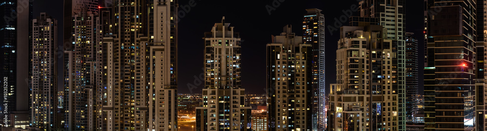 Panorama of new residential buildings in Dubai at night.