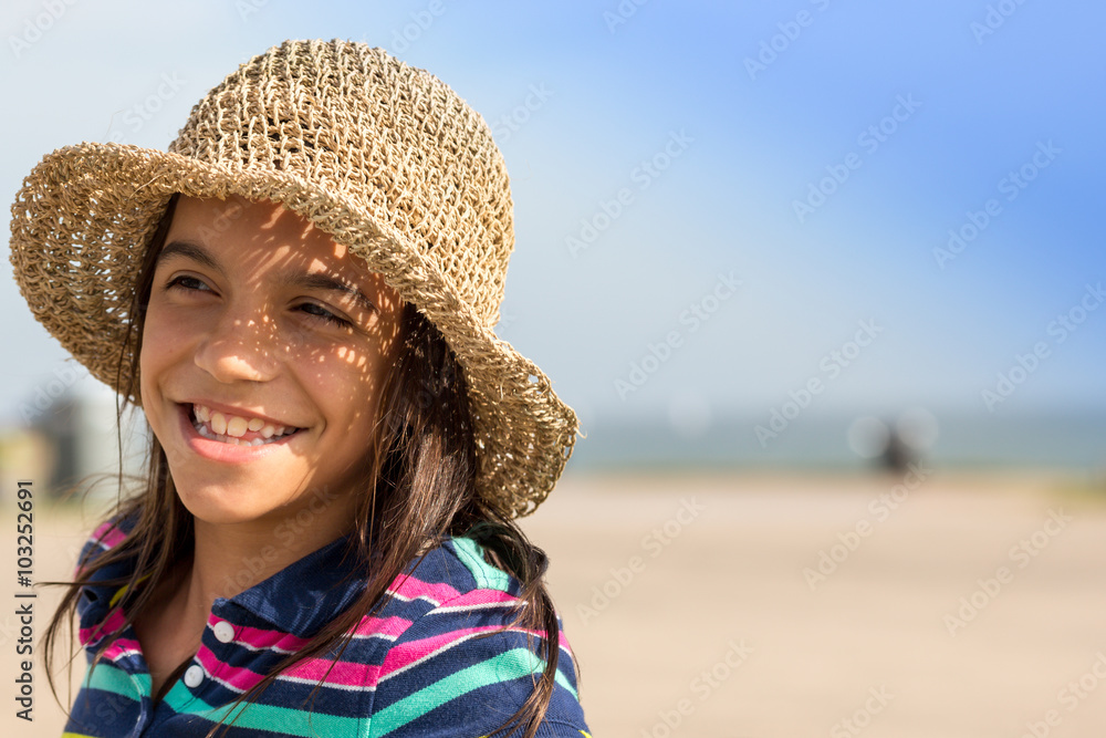 Young girl at beach with hat