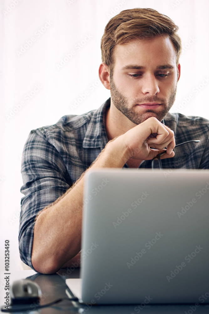 Young self employed writer working on his laptop Young self employed writer working on his laptop