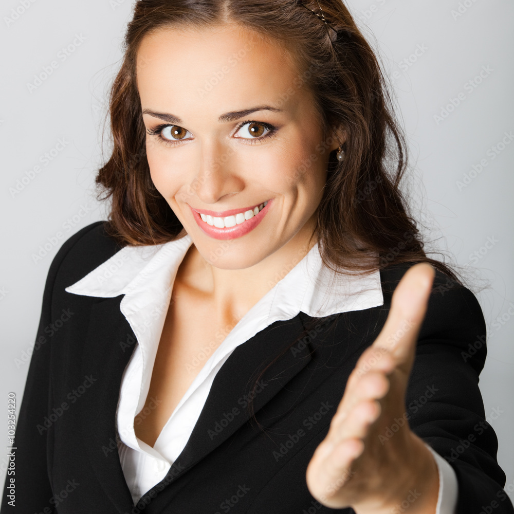 Business woman giving hand for handshake, over grey Business woman giving hand for handshake, over grey