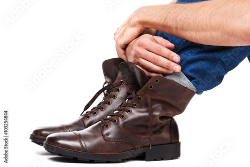 Male legs in jeans and leather boots