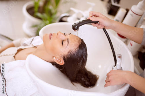 Obraz na płótnie Young woman washing hair in salon