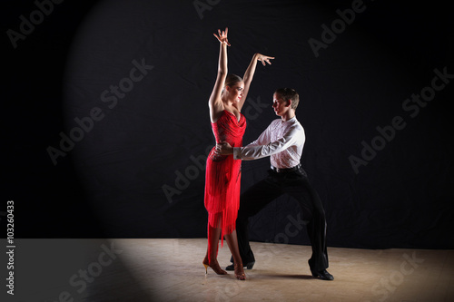 Latino dancers in ballroom isolated on black