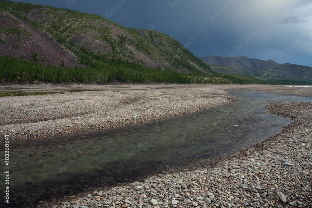 The mountain river in a stony way. River Labynkyr. Oimyakon Highlands. Yakutia. Russia. The mountain river in a stony way. River Labynkyr. Oimyakon Highlands. Yakutia. Russia.