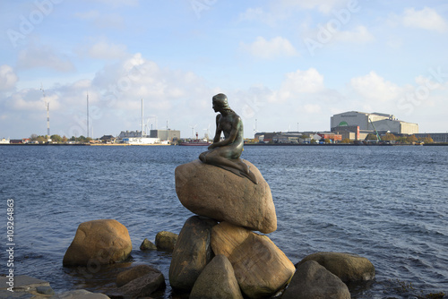 Скульптура Русалочки на фоне портовой набережной Копенгагена. Дания