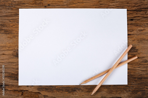 White paper with pencil on wooden table