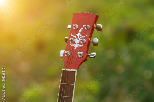 blurry and soft focus of guitar on grass at sunset photo