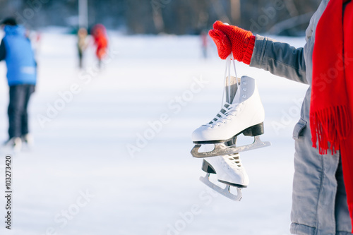 Young woman showing ice skates for winter 