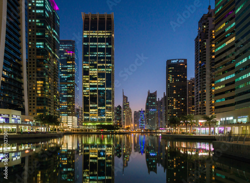 Jumeirah Lake Towers in Dubai, UAE. Glittering lights and tallest skyscrapers during a clear evening with blue sky.  © kapros76