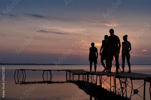 Three men and one girl to go swimming at sunset