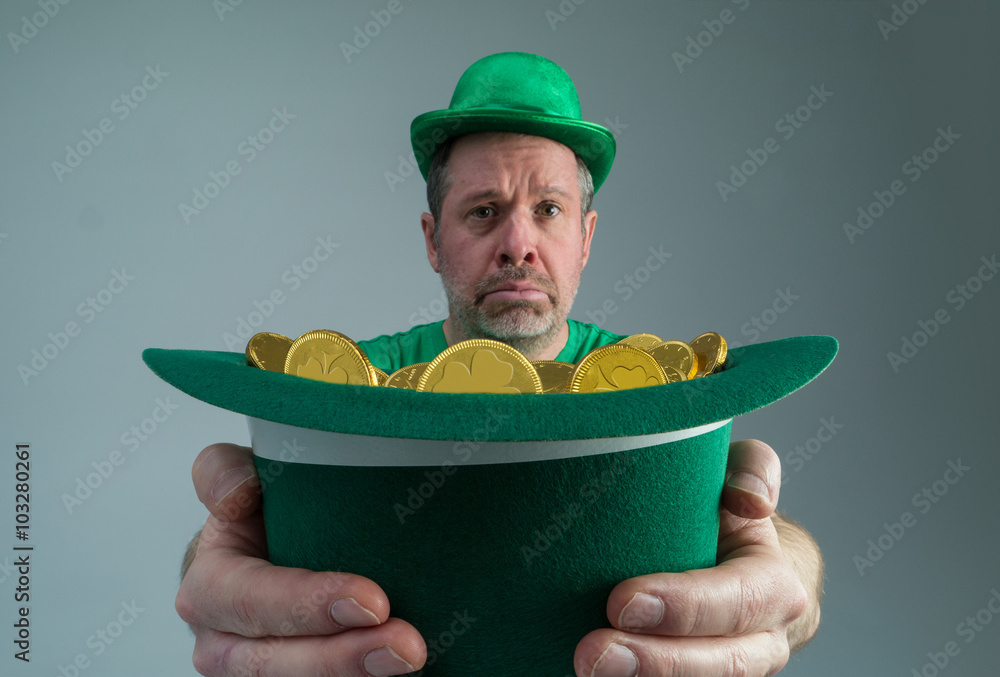 Photograph of a very sad Leprechuan holding out a green hat full of gold coins. Photograph of a very sad Leprechuan holding out a green hat full of gold coins.