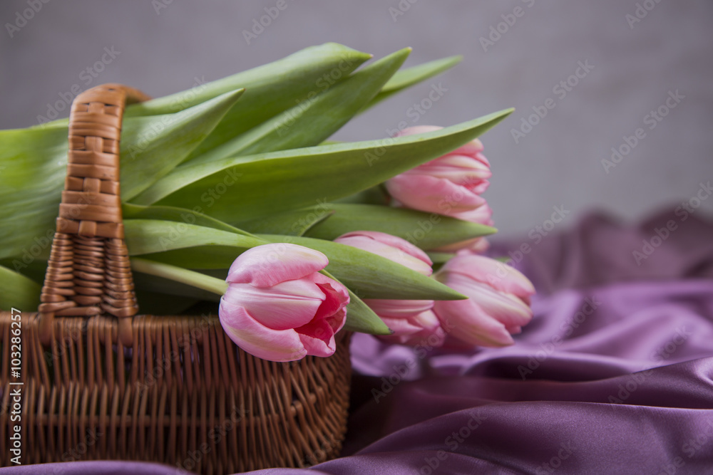 Wicker basket with bouquet of pink tulips