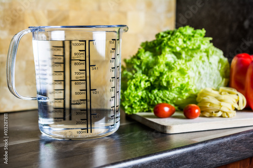 1000ccm / 1 Liter / 1000ml Of Water In A Measuring Cup On A Kitchen Counter With Food photo