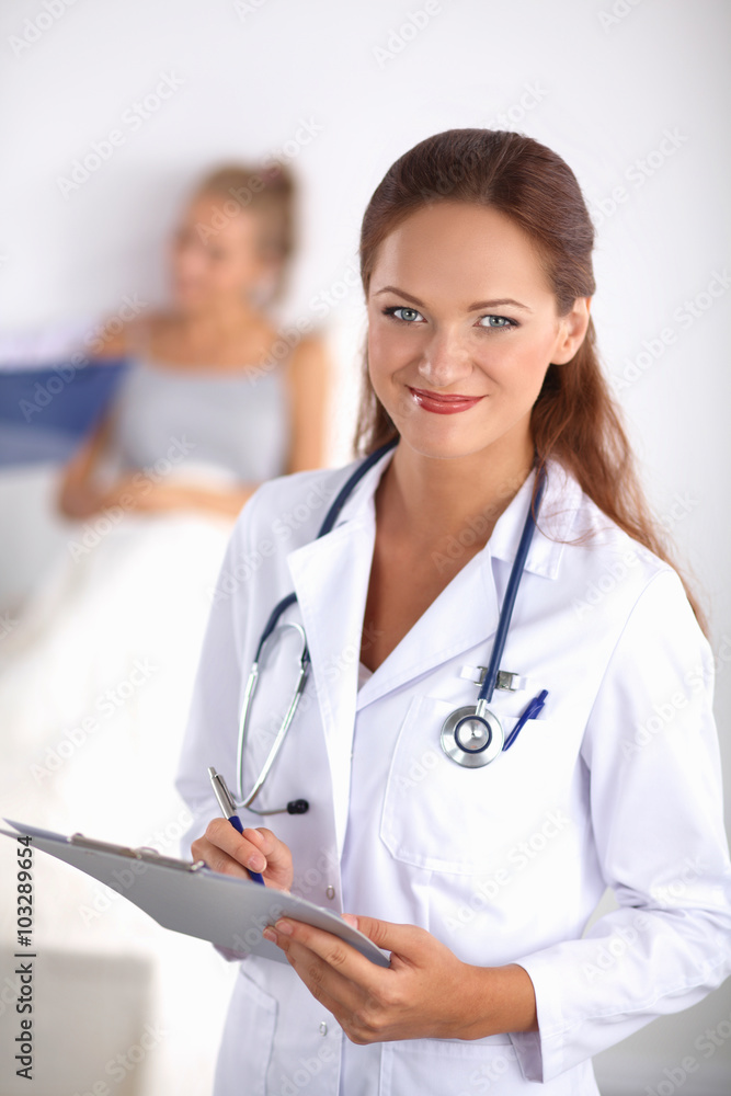 Smiling female doctor with a folder in uniform standing at hospital Smiling female doctor with a folder in uniform standing at hospital