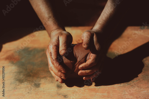 Close up of man's hand holding pottery clay photo