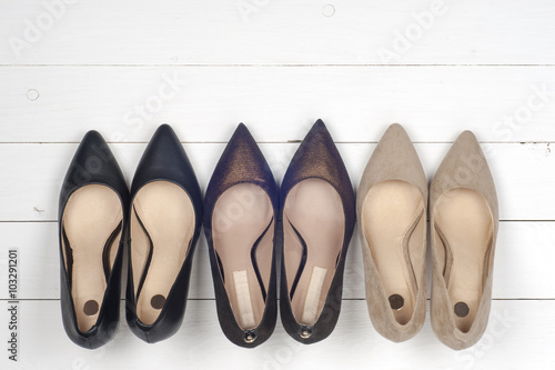 Pile of various female shoes on wooden background