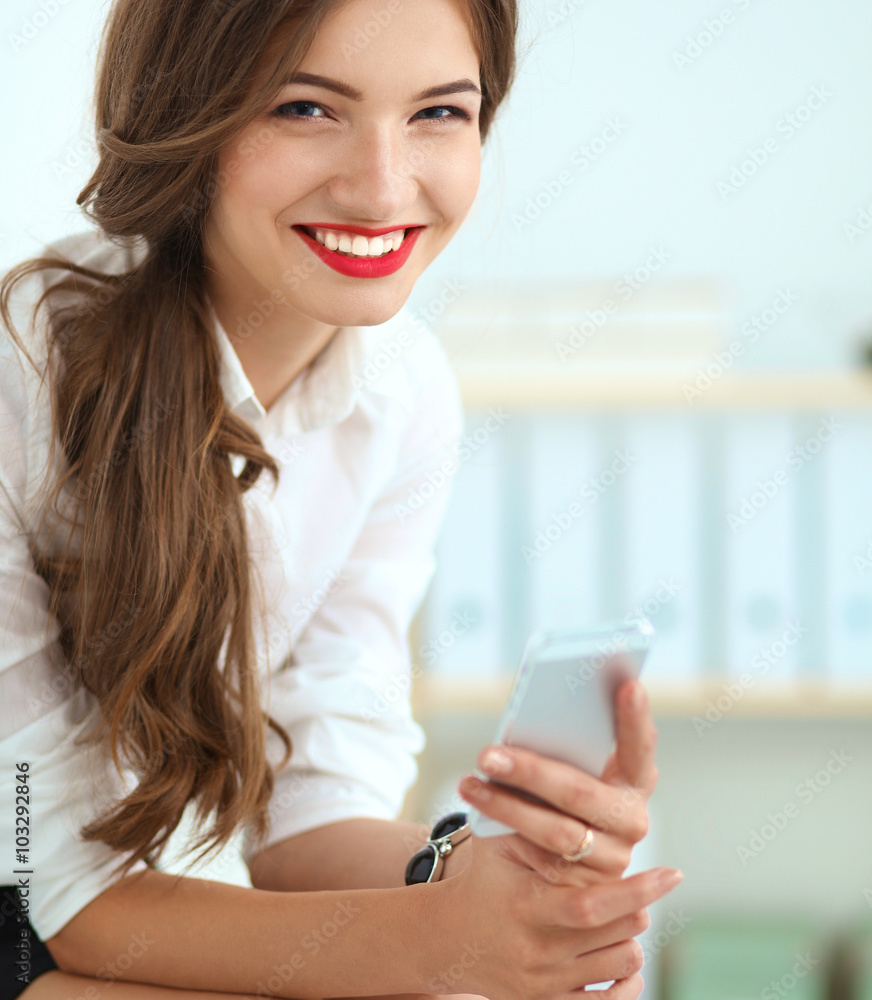 Attractive young businesswoman sitting in the office Attractive young businesswoman sitting in the office