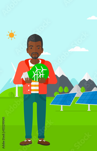 Man holding lightbulb with windmills inside.