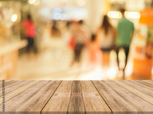 Wallpaper Mural Wooden board empty table in front of people shopping at market fair background. Perspective wood and blur market - can be used for display or montage your products - vintage effect style pictures. Torontodigital.ca