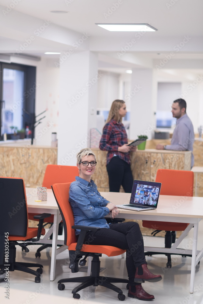 portrait of young business woman at office with team in backgrou