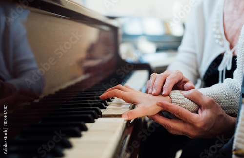 experienced hand of old music teacher helps child pupil