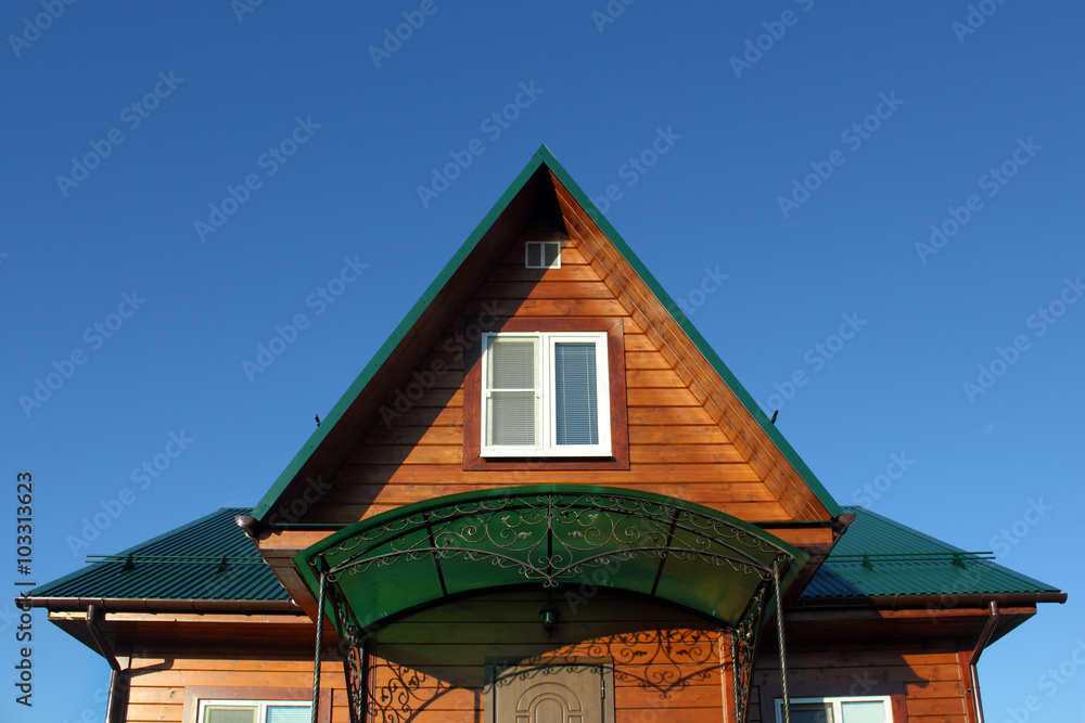 Green metal roof and attic window front view