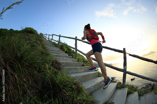 young fitness woman trail runner on seaside mountain stairs © lzf