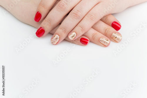 Woman hands with red and gold manicure