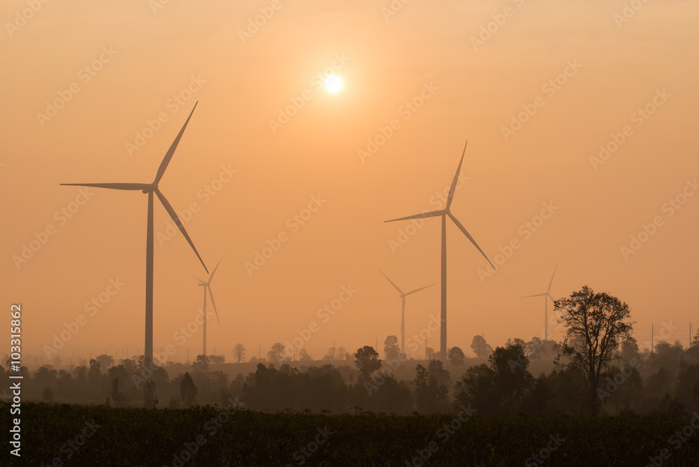 silhouette of wind turbines at sunset