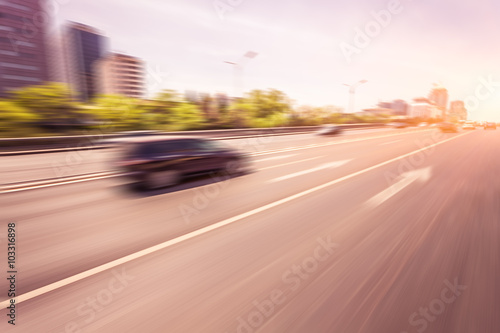 Car driving on road at sunset, motion blur