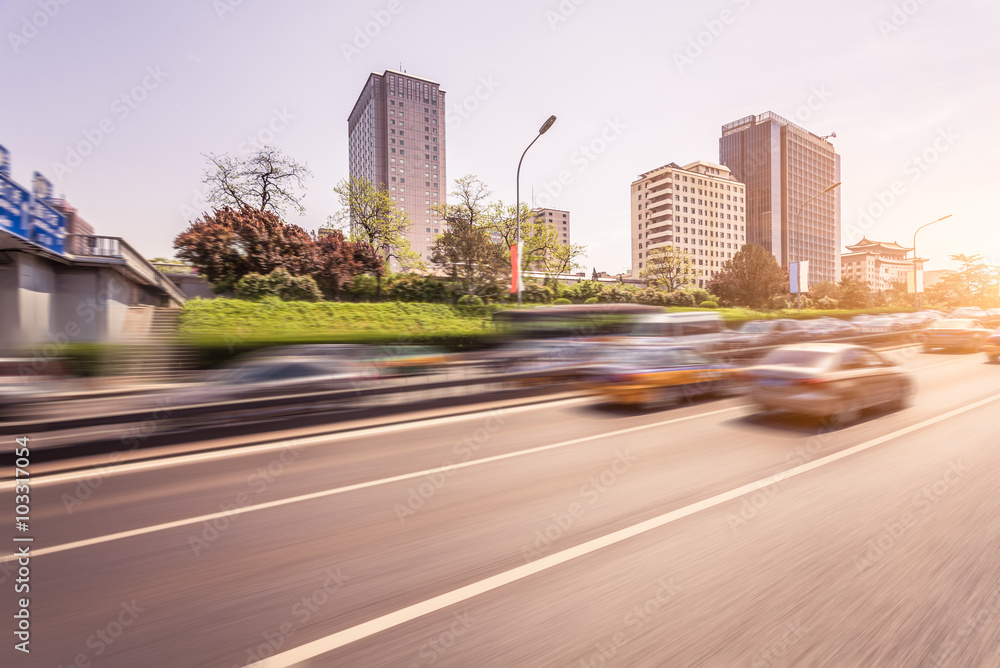 Obraz premium Car driving on road at sunset, motion blur