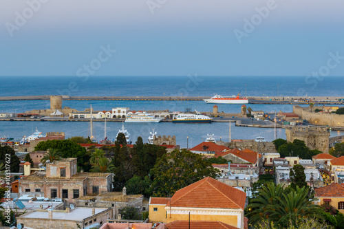  Greece, Rhodes. Panorama of the port and the old town in the evening.
