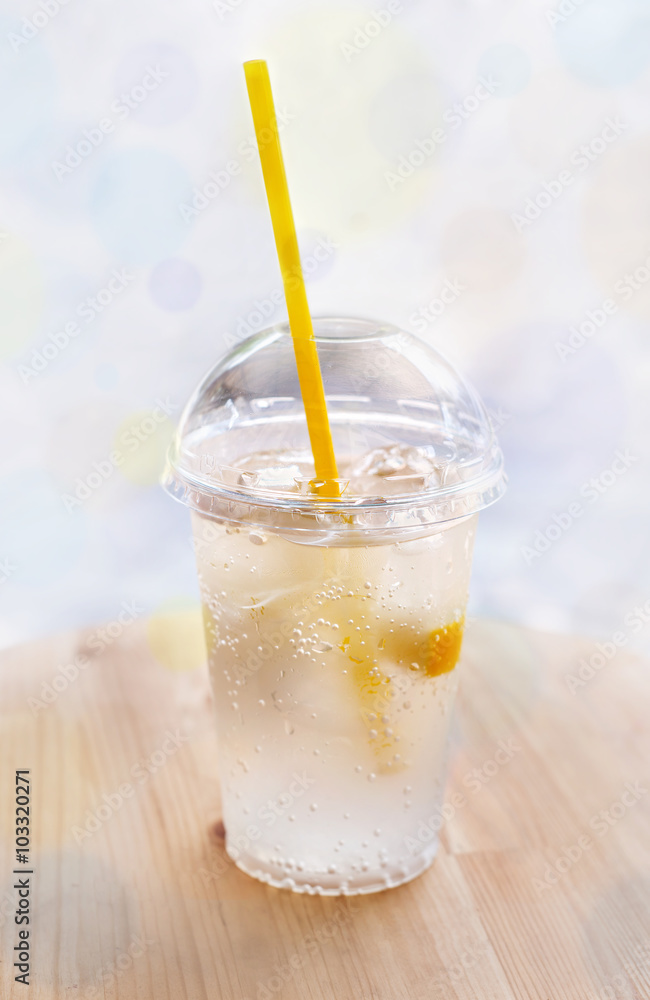 Lemonade, a refreshing drink in a plastic cup. Street backgrou Lemonade, a refreshing drink in a plastic cup. Street backgrou