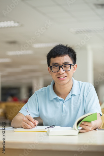Asian student working in the library.