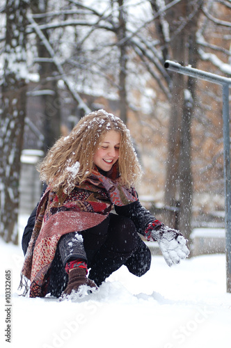 Curly girl sitting in snow