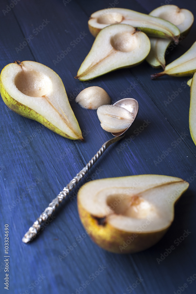 The pear halves with spoon on dark blue wooden table